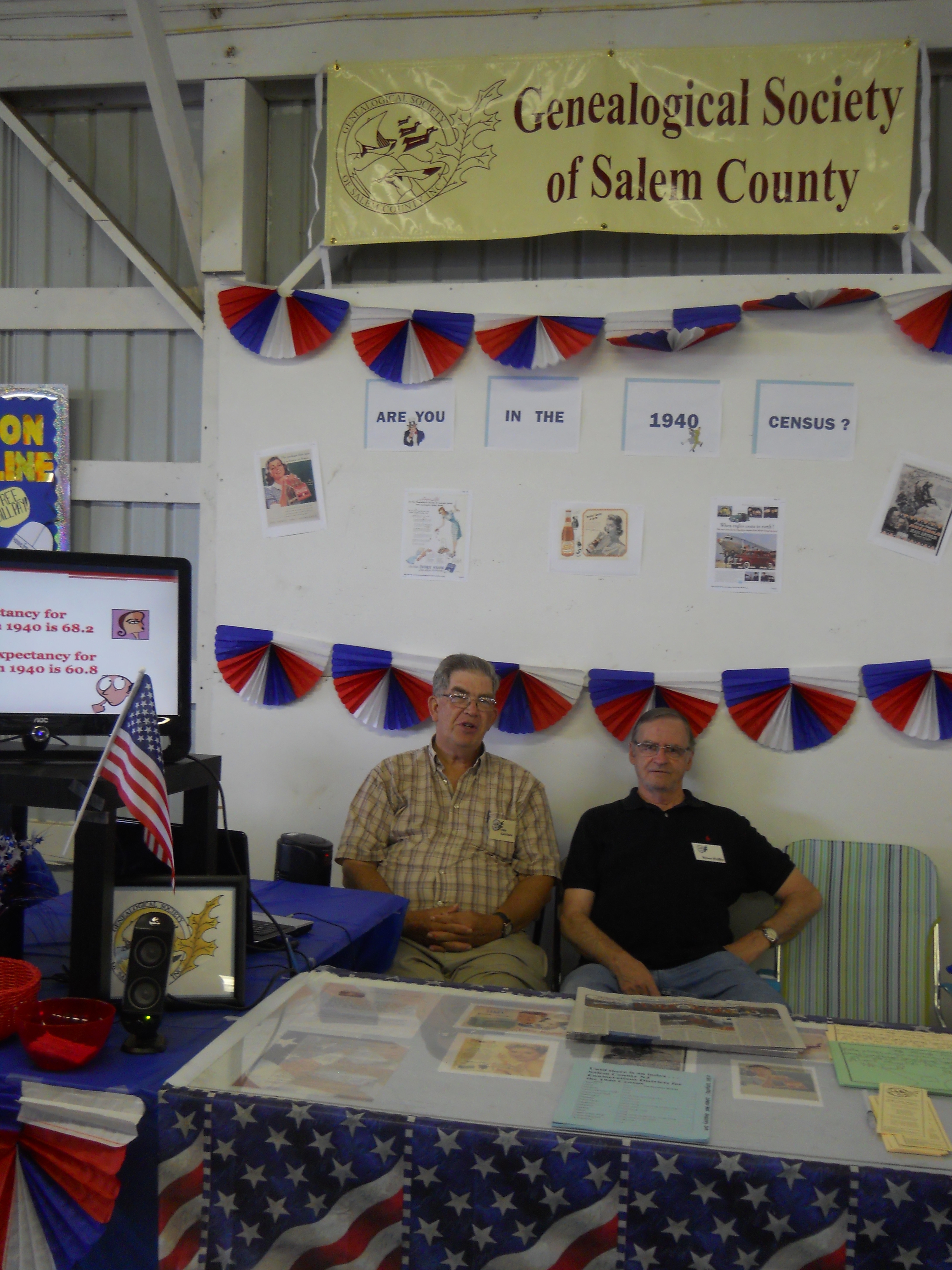 Two members pose at the Genealogical Society's 1940s Census themed booth