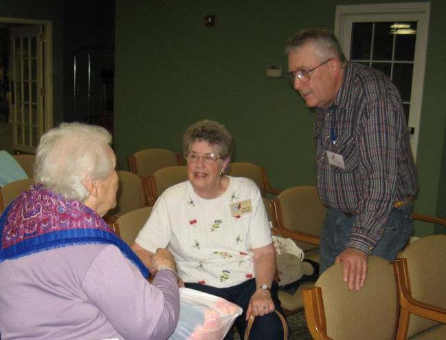 Past President Bill Stoms and Newsletter Editor Anne Rossell chat with Past President Ruth Hall Brooks