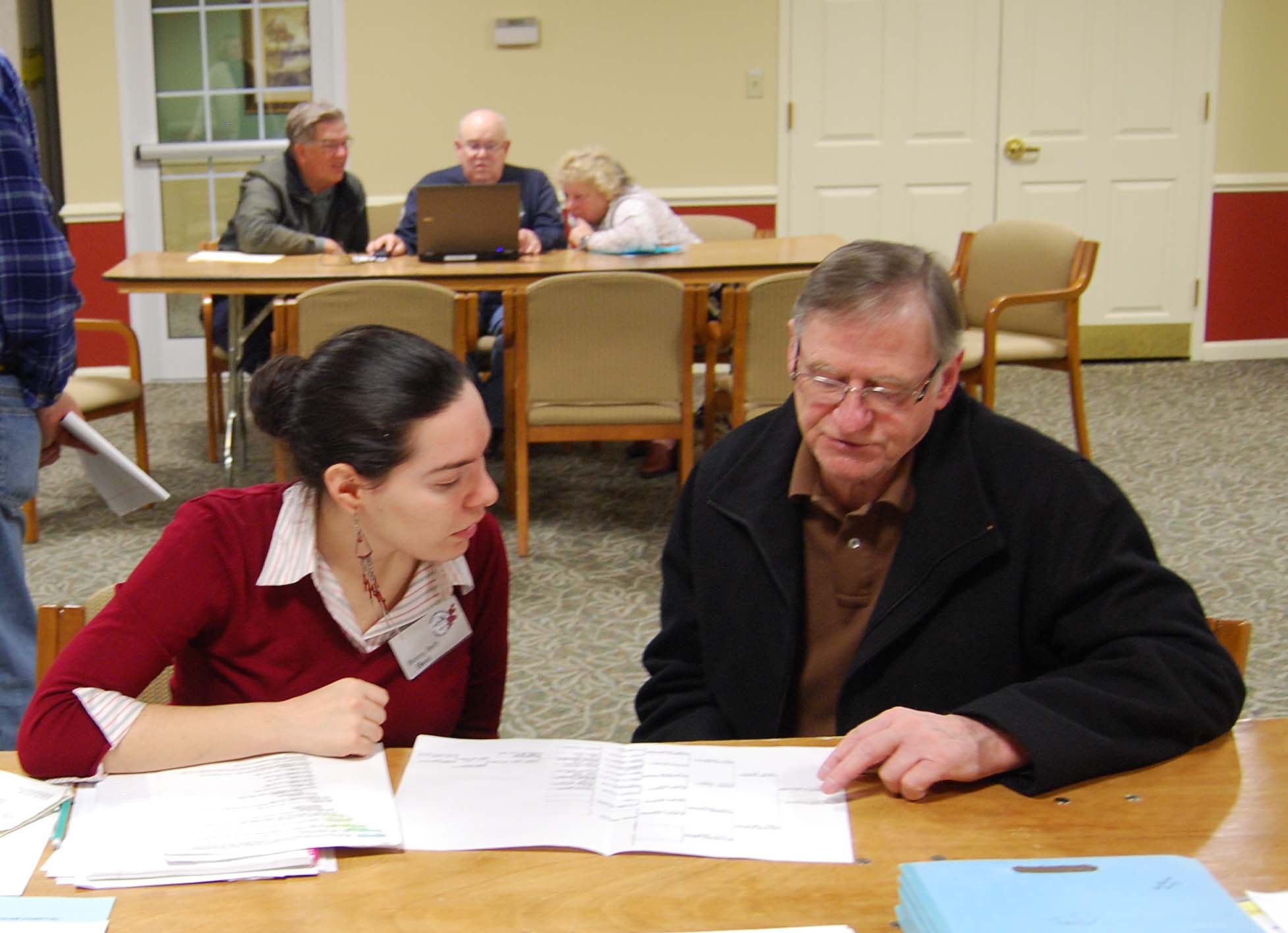President Bonny Beth Elwell compares family trees with a fellow member at a Genealogical Society workshop